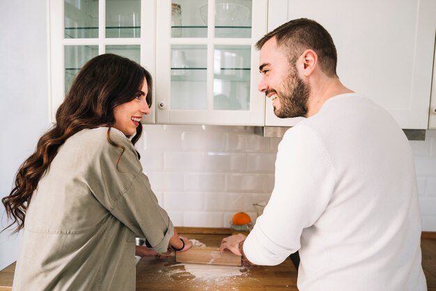 Couple rolling dough together