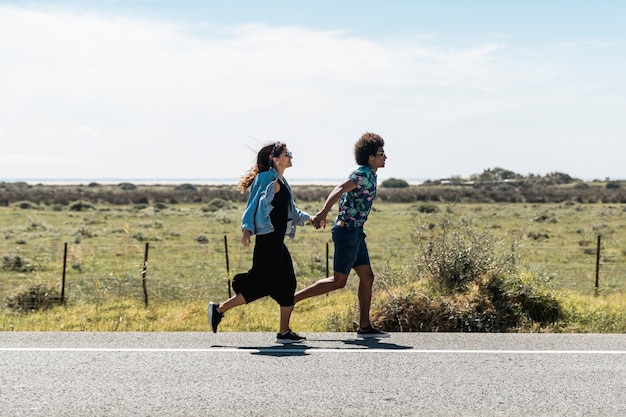 Couple running on sunny road