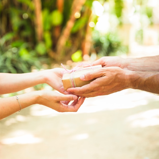 Couple's hand holding tied valentine gift