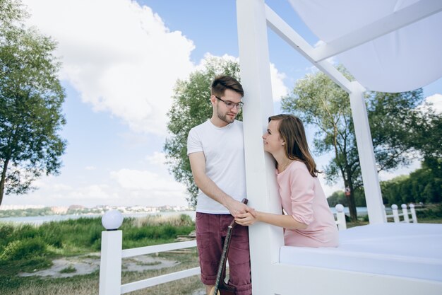 Couple separated by a column with a guitar holding hands