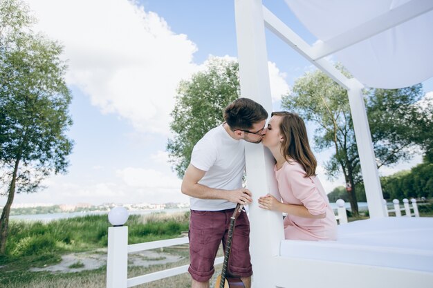 Couple separated by a column with a guitar kissing