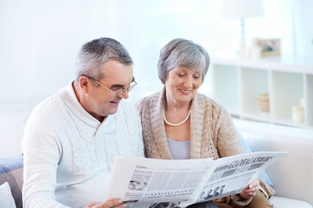 Couple sharing a newspaper