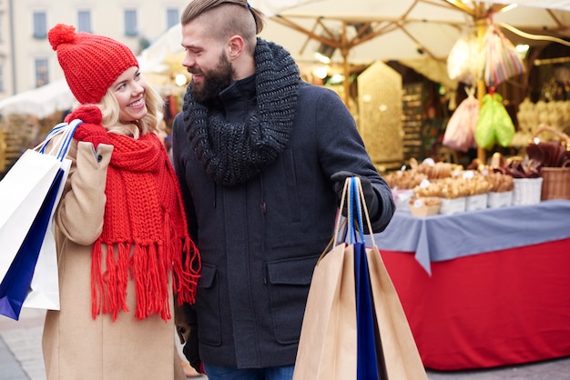 クリスマスマーケットで買い物をするカップル