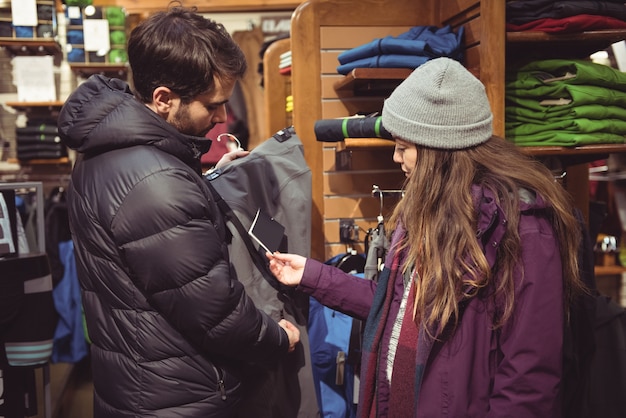 Пара, делающая покупки в магазине одежды