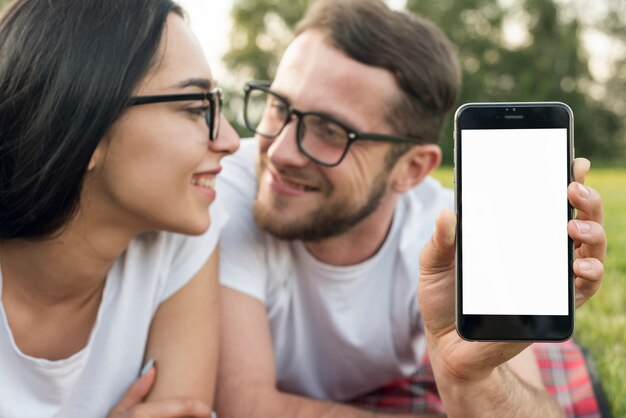 Couple showing technological device in the park