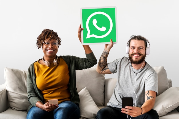 Free photo couple showing a whatsapp messenger icon