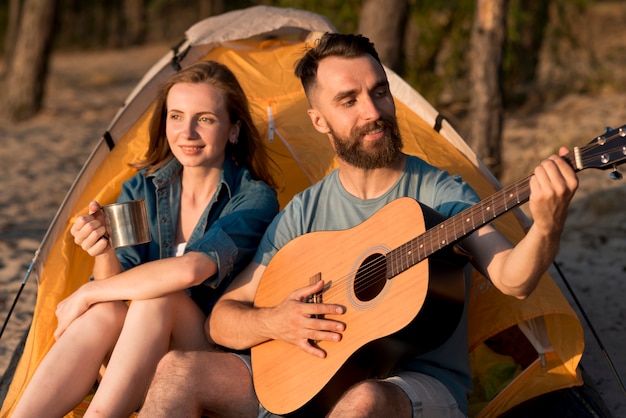 Free photo couple singing and drinking at camping