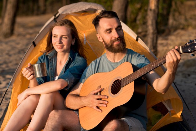 Couple singing and drinking at camping