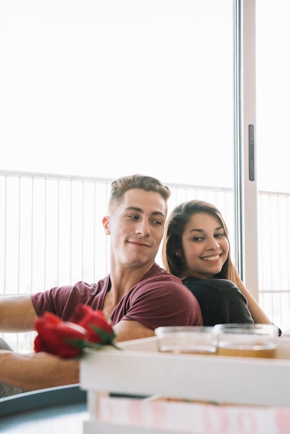 Couple sitting back to back on floor 