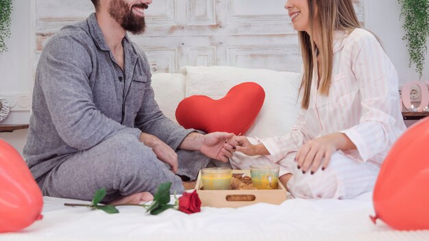 Couple sitting on bed and holding hands 