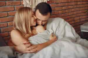 Free photo couple sitting on a bed in a room