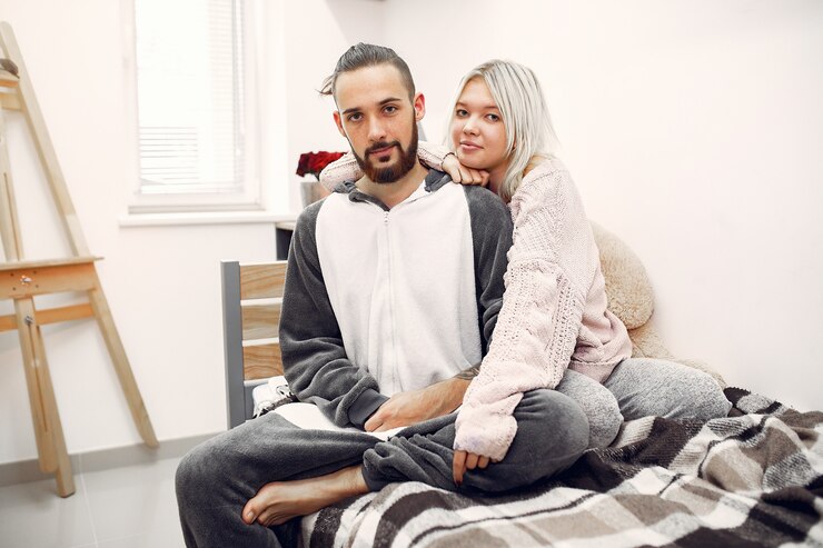 Free Photo couple sitting on a bed in a room