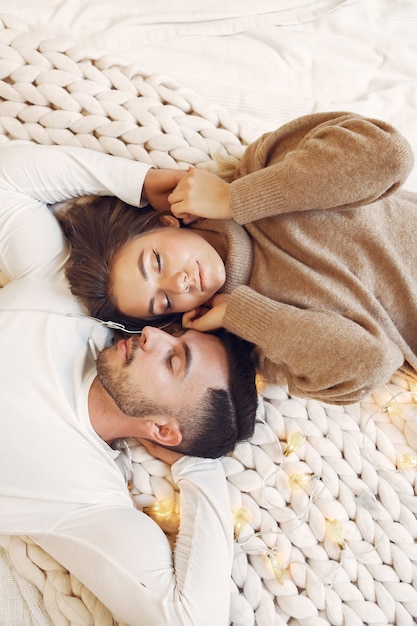 Free photo couple sitting on a bed in a room