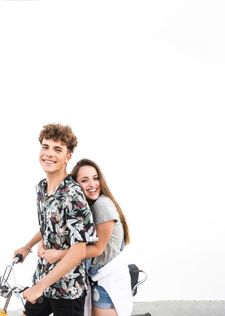 Couple sitting on bicycle against white background