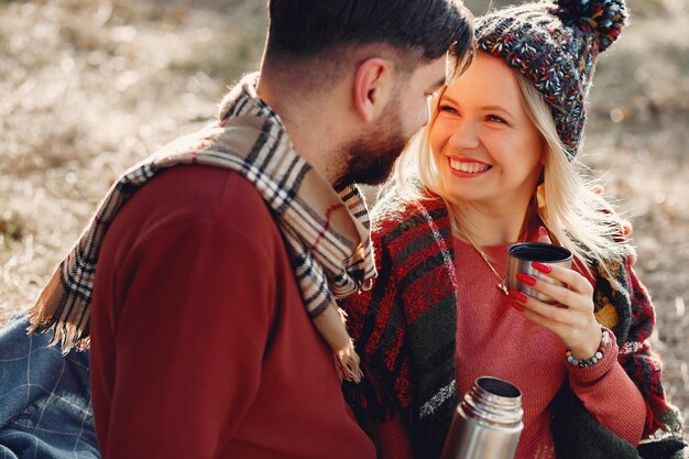 Free photo couple sitting by a tree in a spring forest