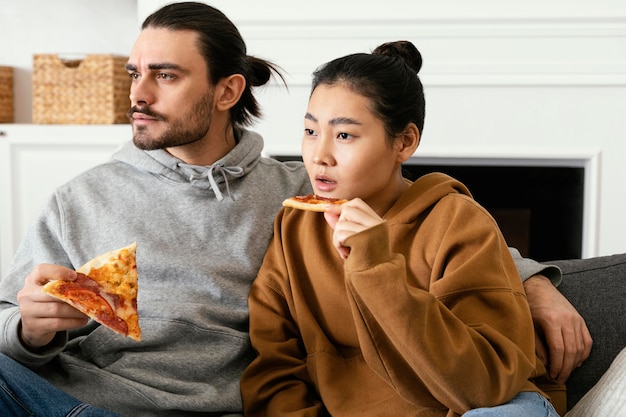 Free photo couple sitting on the couch and watching tv