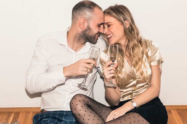 Couple sitting on floor with champagne glasses 