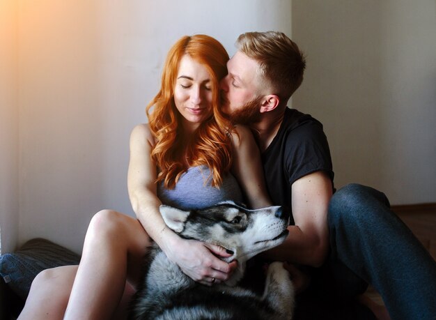 Couple sitting on the floor with their dog