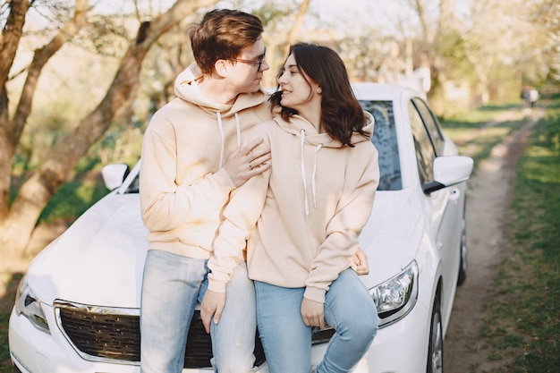 Couple sitting on a hood of car in a park