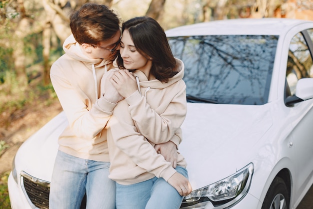 Couple sitting on a hood of car in a park