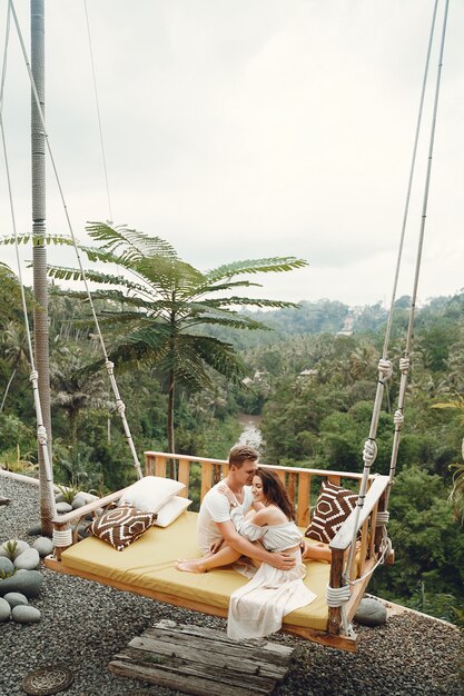 Couple sitting on a large swing on a Bali