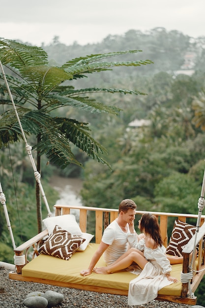 Couple sitting on a large swing on a Bali
