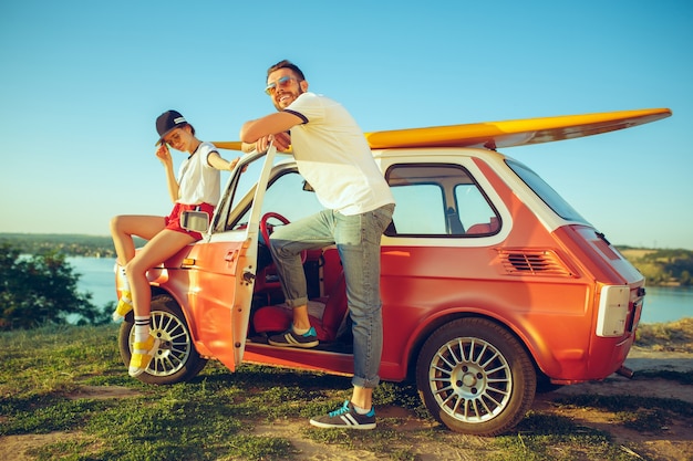 Couple sitting and resting on the beach on a summer day near river. Caucasian man and woman