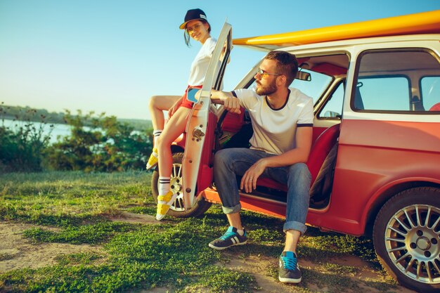 Couple sitting and resting on the beach on a summer day near river