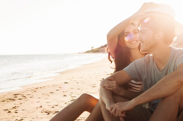 Couple sitting next to the sea on a beautiful day