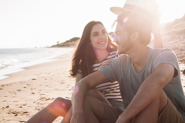 Couple sitting next to the sea with sun effect