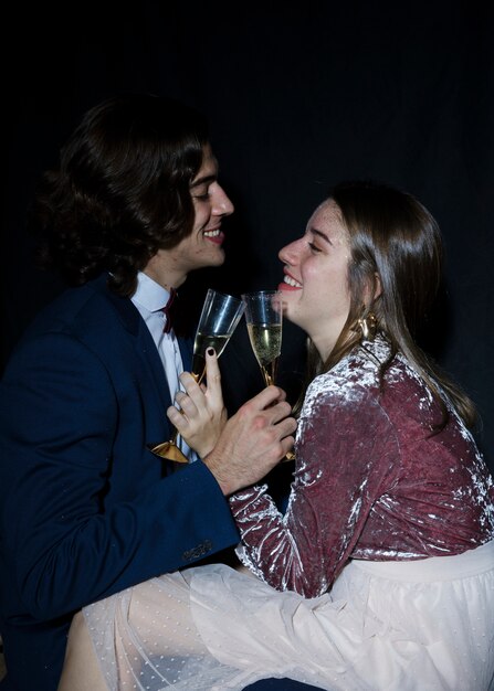 Couple sitting with champagne glasses in hands 