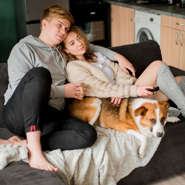 Free photo couple sitting with dog on couch