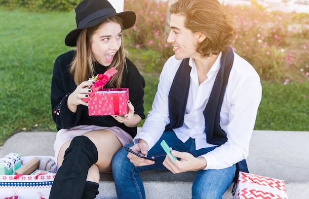 Couple sitting with gift box on bench