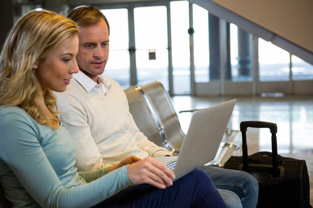 Couple sitting with laptop in the waiting area
