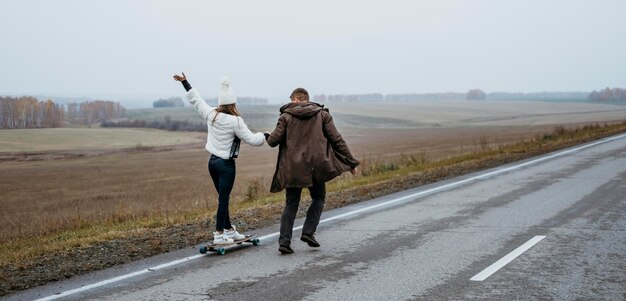 Couple skateboarding outdoors together