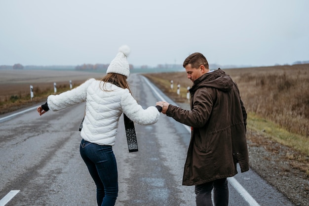 Couple skateboarding on the road