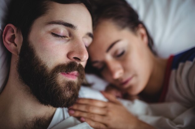 Пара спит вместе на кровати