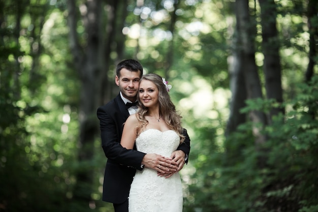 Free photo couple of smiling newlyweds posing outdoors