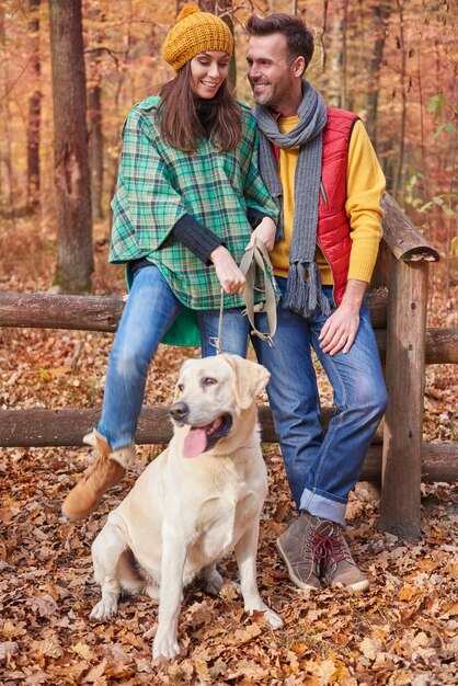 Couple spending time with dog in forest