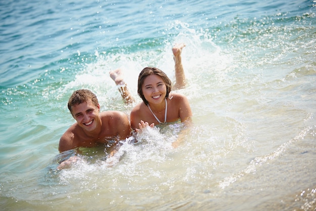 Couple splashing water in the sea