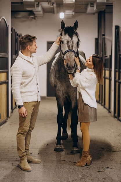 Couple in stable with horse