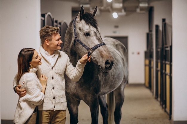 Couple in stable with horse