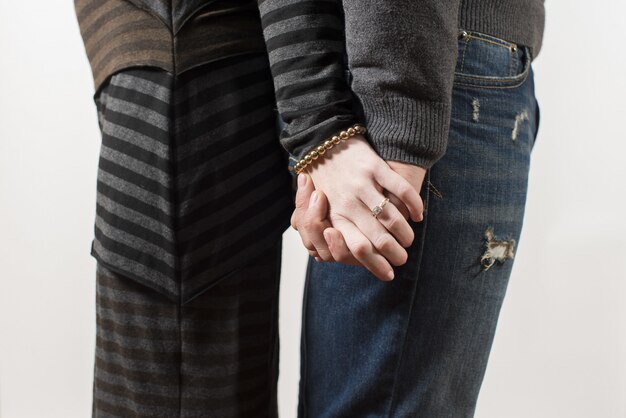 couple standing back to back while holding hands