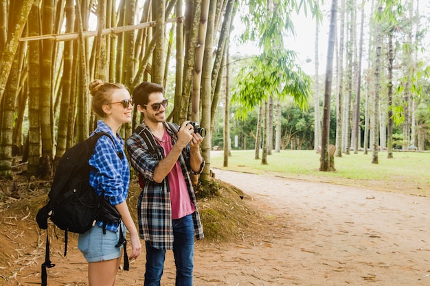 Free photo couple standing in front of forest