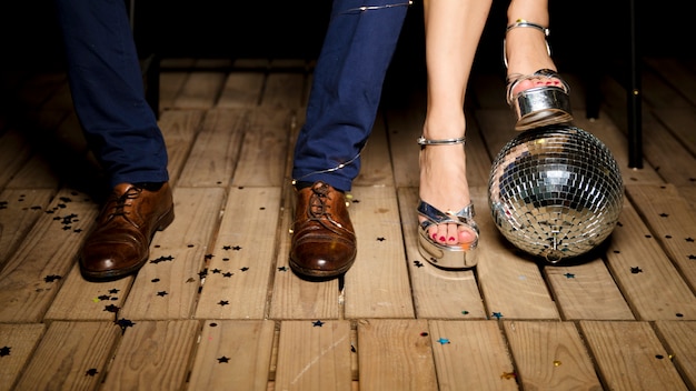 Бесплатное фото Пара, стоя на деревянном полу с диско шар