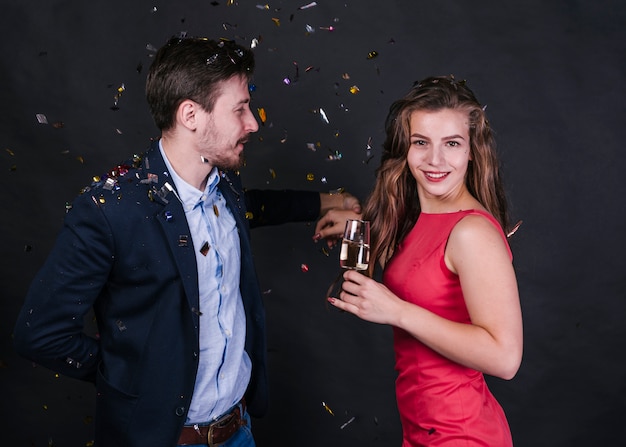 Couple standing under spangles with champagne glass 