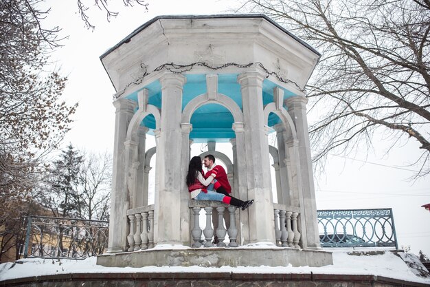 "Couple in stone pavilion in winter"
