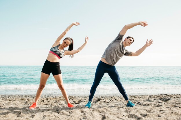 Couple stretching at the beach