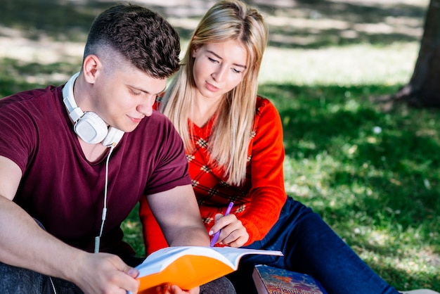 Free photo couple studying together in park