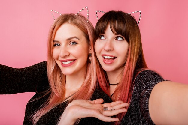 Couple of stunning women with stylish dresses and cat ears posing